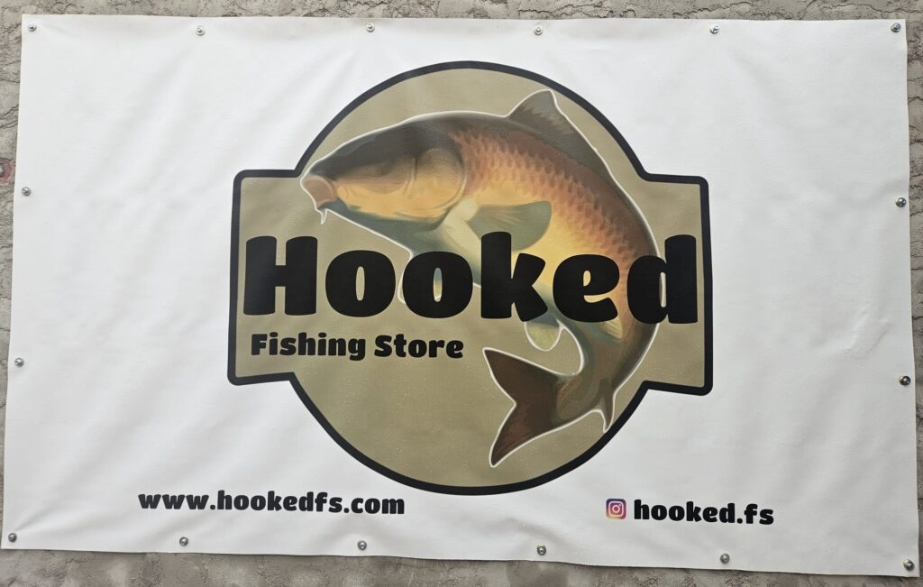Imagen de una lona frontlit con ojales para exterior con el logo del cliente Hooked Fishing Store